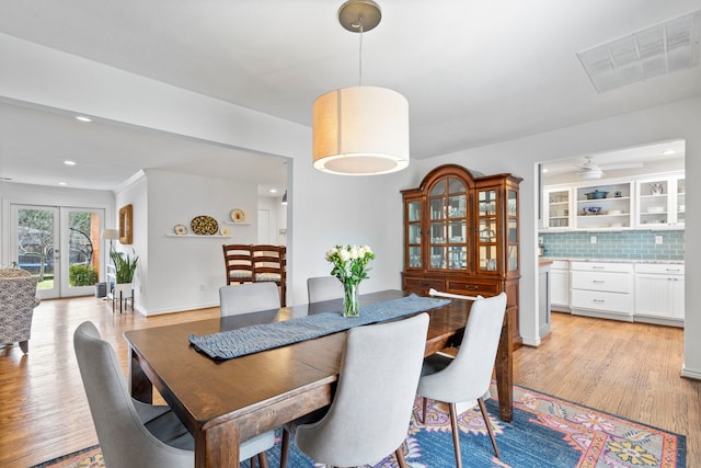 dining space featuring french doors, light wood finished floors, recessed lighting, visible vents, and baseboards