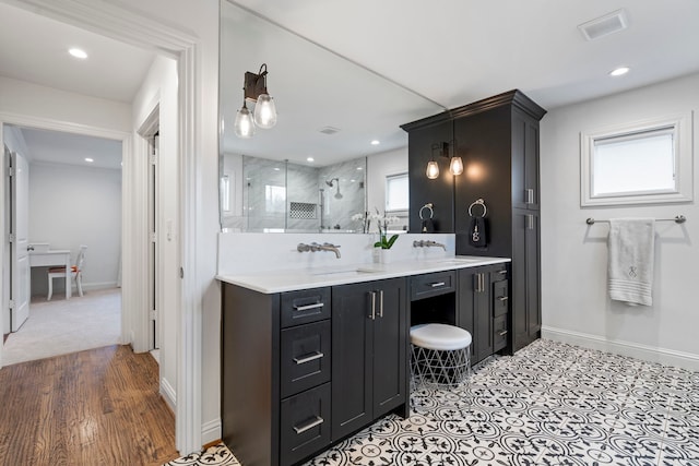 bathroom featuring a stall shower, visible vents, baseboards, vanity, and recessed lighting