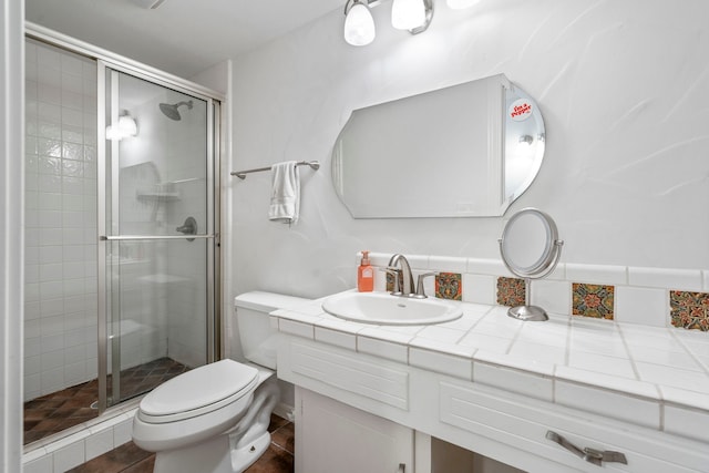 full bath with vanity, a shower stall, and toilet