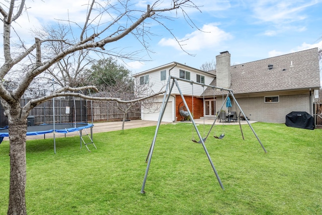 back of house featuring a patio area, a trampoline, a chimney, and fence