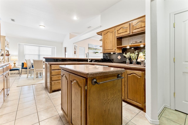 kitchen with light tile patterned floors, decorative backsplash, a kitchen island, a peninsula, and open shelves