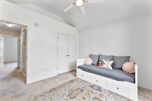 bedroom with vaulted ceiling, carpet floors, a closet, and baseboards