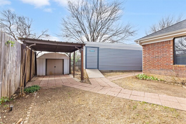 exterior space featuring an outbuilding, a fenced backyard, a storage shed, and a detached carport