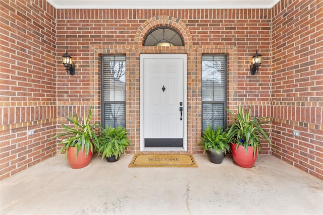 doorway to property featuring brick siding