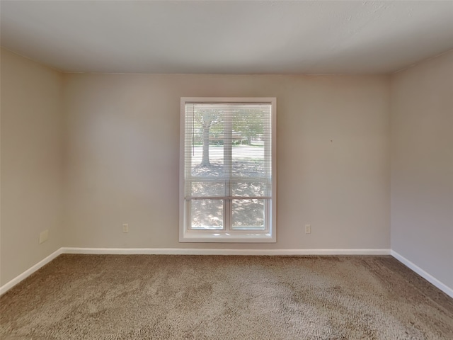 carpeted spare room featuring baseboards