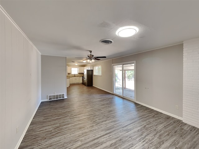 unfurnished living room featuring dark wood-style floors, visible vents, and crown molding