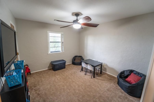 interior space featuring a ceiling fan, carpet flooring, and baseboards