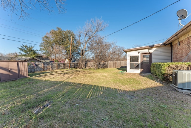 view of yard with an outbuilding, central AC, a storage unit, and a fenced backyard