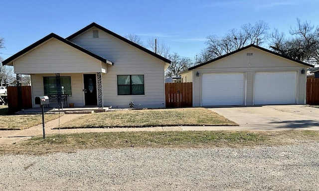 view of front of house with a garage, an outbuilding, covered porch, and fence