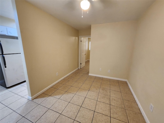 empty room featuring light tile patterned flooring and baseboards