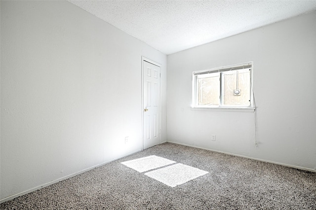 unfurnished room featuring carpet, baseboards, and a textured ceiling