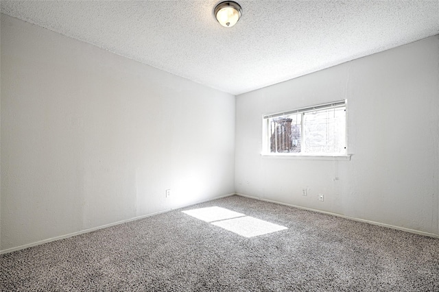 carpeted empty room featuring a textured ceiling