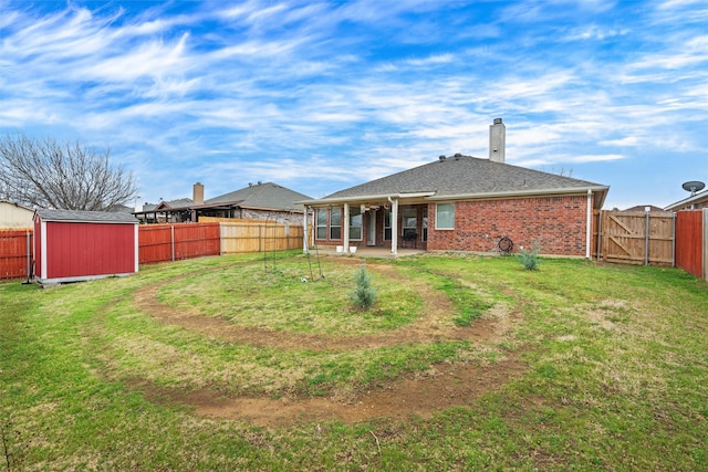 back of property featuring a storage shed, a fenced backyard, an outdoor structure, a patio area, and brick siding