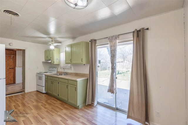 kitchen with white electric range, a sink, visible vents, light countertops, and green cabinetry