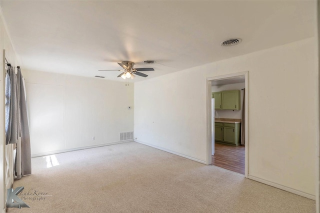 unfurnished room with a ceiling fan, carpet, and visible vents