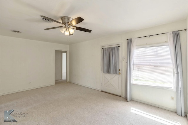 carpeted spare room with ceiling fan and visible vents