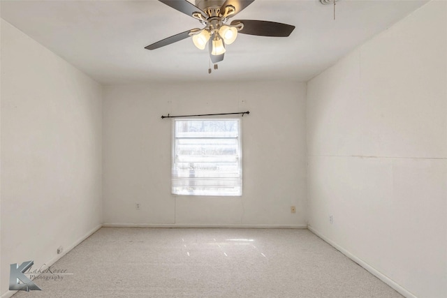 carpeted empty room with a ceiling fan and baseboards