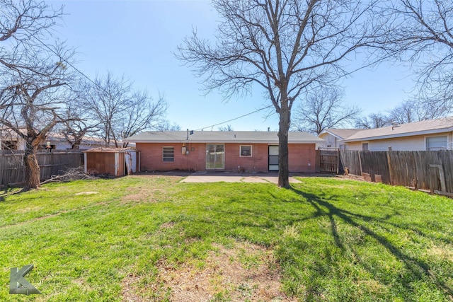 rear view of property with a patio area, a fenced backyard, a lawn, and an outdoor structure