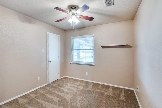 carpeted empty room featuring visible vents, ceiling fan, a textured ceiling, and baseboards