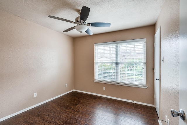 unfurnished room with a textured ceiling, baseboards, wood finished floors, and a textured wall