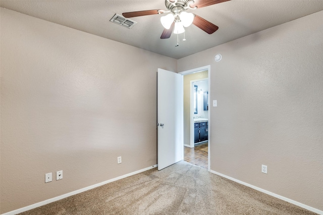 unfurnished room with visible vents, ceiling fan, light carpet, and baseboards