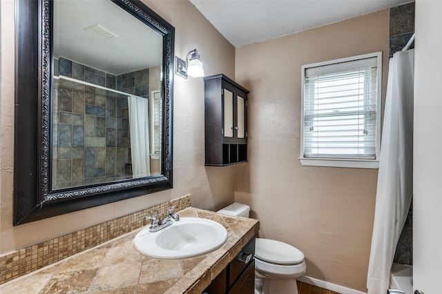 bathroom featuring curtained shower, vanity, toilet, and baseboards