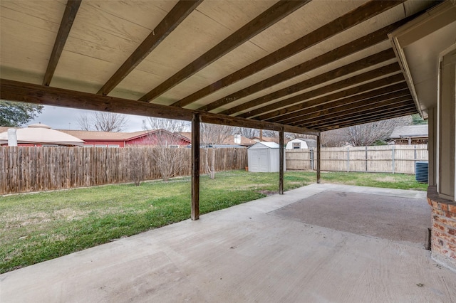 view of patio / terrace featuring an outbuilding, a storage unit, and a fenced backyard