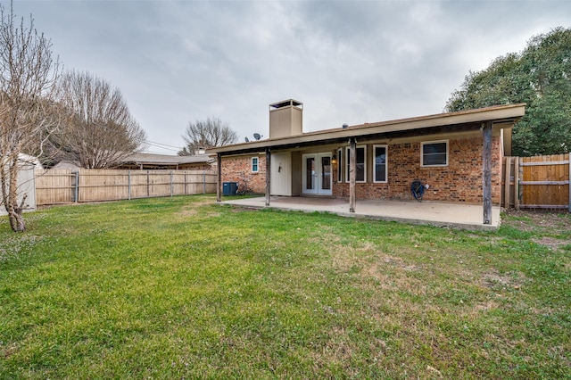 back of property featuring french doors, brick siding, a patio, and a fenced backyard