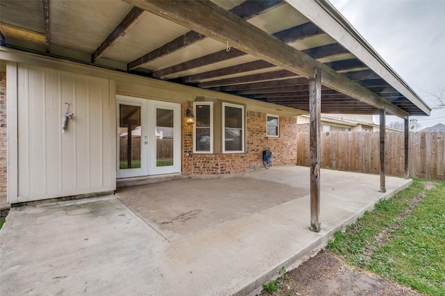 view of patio / terrace featuring french doors, fence, and an attached carport