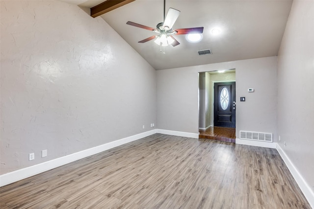 unfurnished room with vaulted ceiling with beams, wood finished floors, visible vents, and baseboards