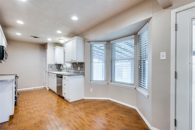 kitchen with white cabinetry, baseboards, visible vents, and stainless steel appliances