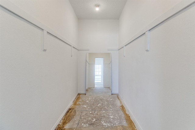 hallway featuring a high ceiling and baseboards