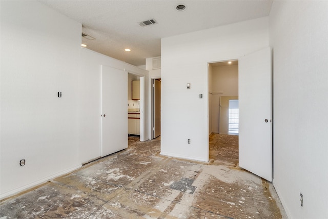 unfurnished bedroom with visible vents and connected bathroom