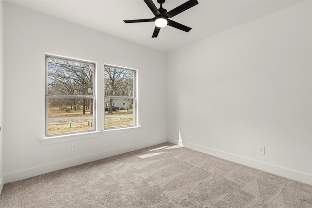 carpeted empty room with a ceiling fan and baseboards