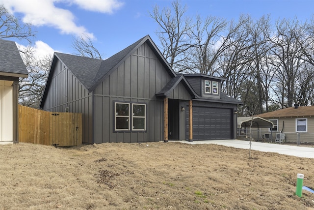 view of front of property with a garage, a shingled roof, fence, concrete driveway, and board and batten siding