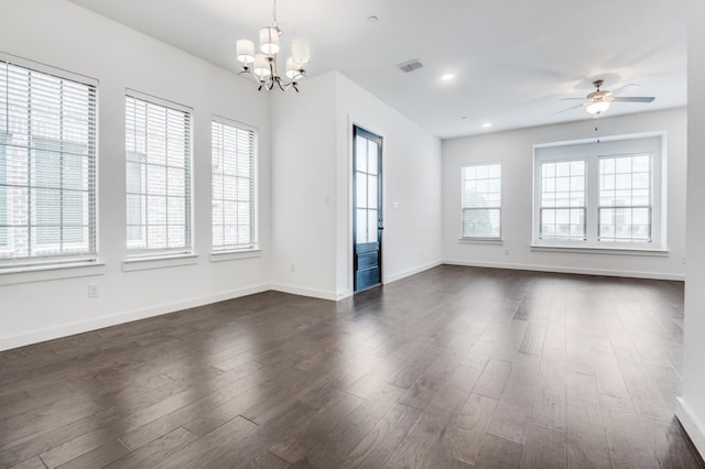 unfurnished room with recessed lighting, ceiling fan with notable chandelier, dark wood-type flooring, visible vents, and baseboards