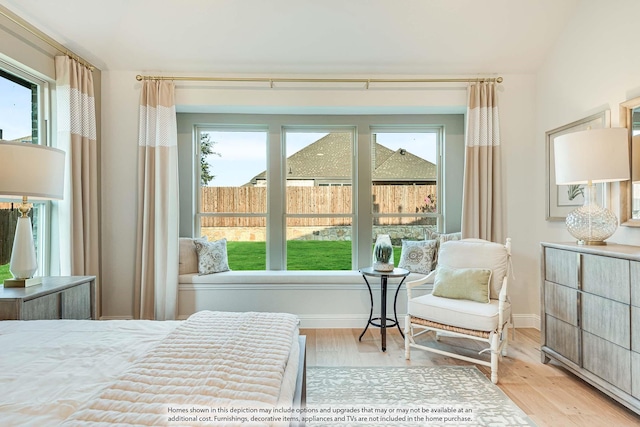 bedroom with multiple windows, baseboards, and wood finished floors