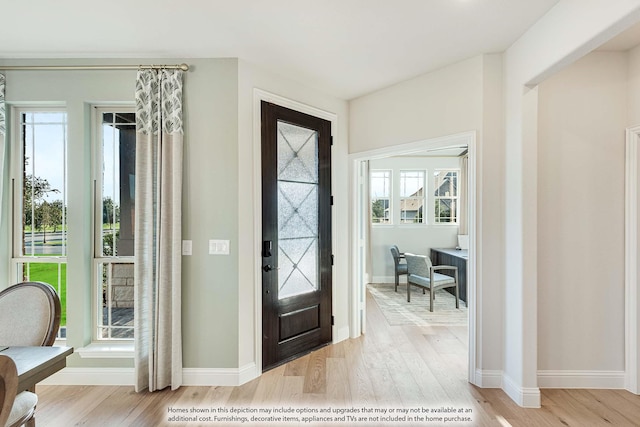 foyer entrance featuring baseboards and light wood-style floors