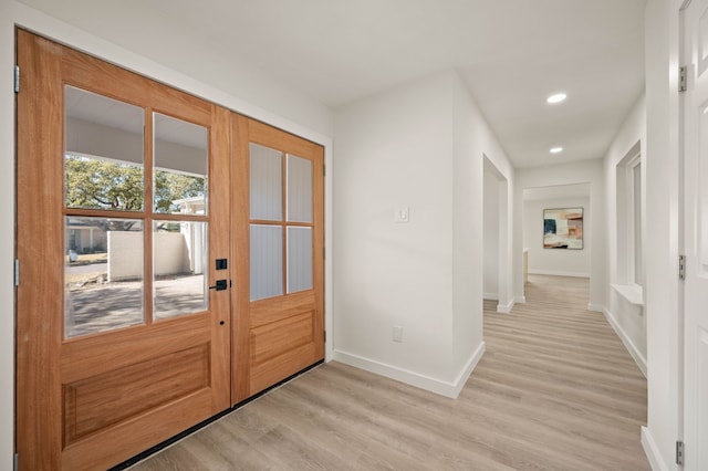 doorway featuring recessed lighting, light wood-style flooring, and baseboards