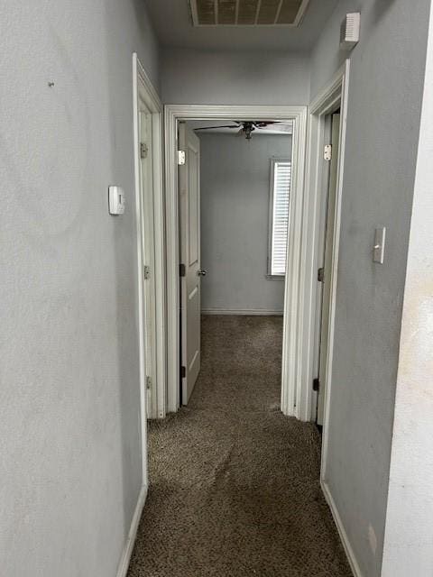 hallway featuring carpet, visible vents, and baseboards