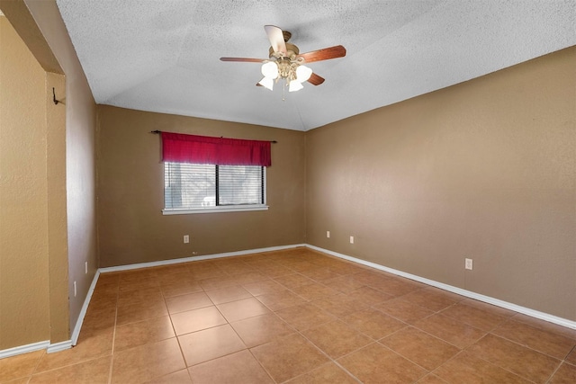 spare room with ceiling fan, a textured ceiling, baseboards, and light tile patterned floors