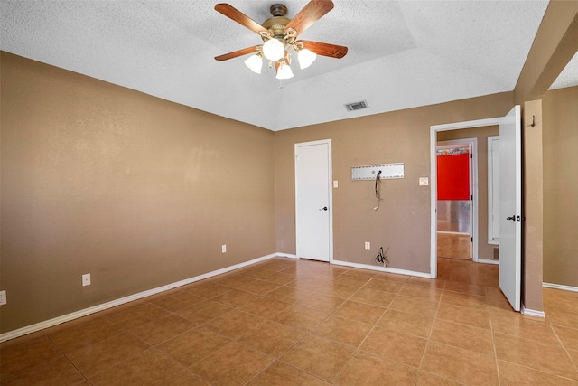 unfurnished room featuring ceiling fan, light tile patterned floors, a textured ceiling, visible vents, and baseboards