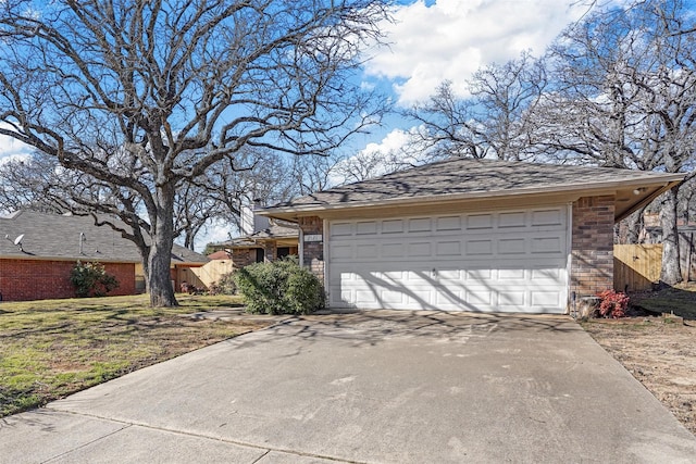 exterior space featuring a garage, a front yard, brick siding, and driveway