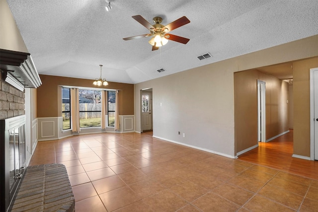 unfurnished living room with lofted ceiling, tile patterned flooring, and visible vents