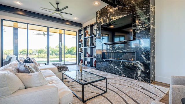 living room with ceiling fan, a fireplace, wood finished floors, and recessed lighting