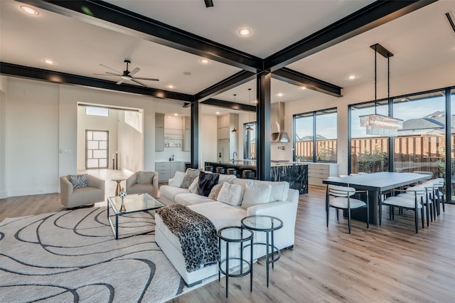 living room featuring ceiling fan, beamed ceiling, light wood-type flooring, and recessed lighting