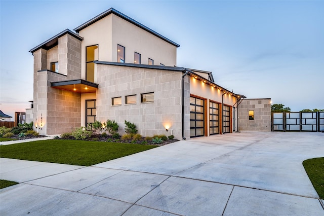 view of front of property with a garage, concrete driveway, a yard, and concrete block siding