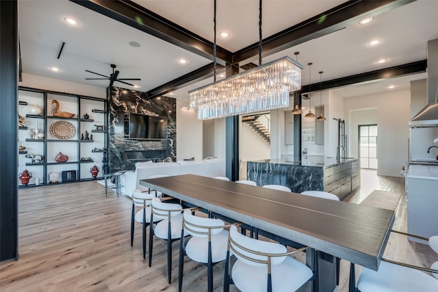 dining room featuring ceiling fan, wood finished floors, beamed ceiling, stairs, and recessed lighting