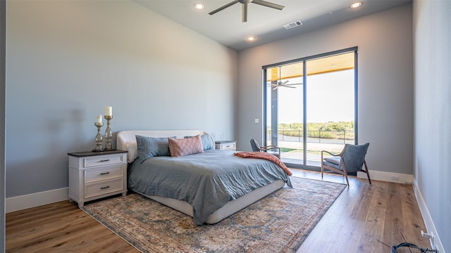 bedroom with access to exterior, baseboards, visible vents, and wood finished floors