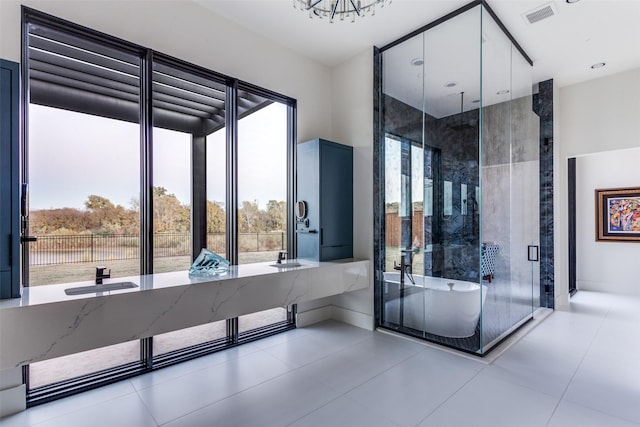 bathroom with a freestanding bath, visible vents, and a healthy amount of sunlight